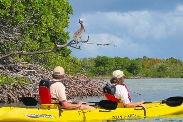 a man in a yellow boat sitting on top of a body of water