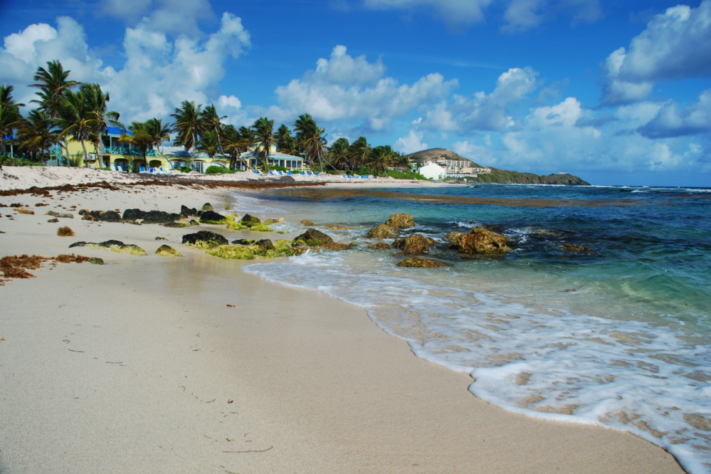 a sandy beach next to a body of water